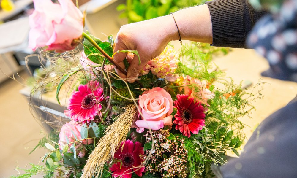 Floristin beim Binden eines Blumenstraußes